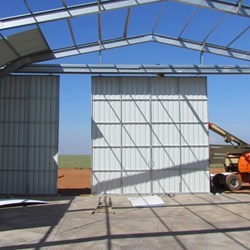 Instalando as abas do portão, pendentes da viga do trilho tornando-as fáceis de abrir e fechar.