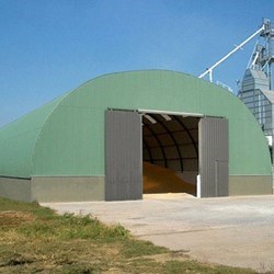 Omega barn on a flood wall to bulk storage of wood pellets