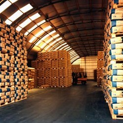 omega steel industrial warehouse with round roof, used to store pallets of cement bags