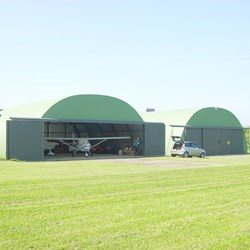 omega steel airport hangar with doors open, showing 2 airplanes parked inside
