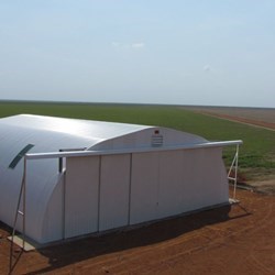Outside view of the finished omega+ hangar, doors closed, plane still parked outside.