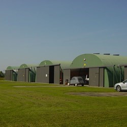 linha de 5 telhados redondos tipo omega num campo de aviação