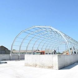 um novo Frisomat Omega + em construção: vista de fora dos pórticos de aço galvanizado montado em cima de um muro de sustentação