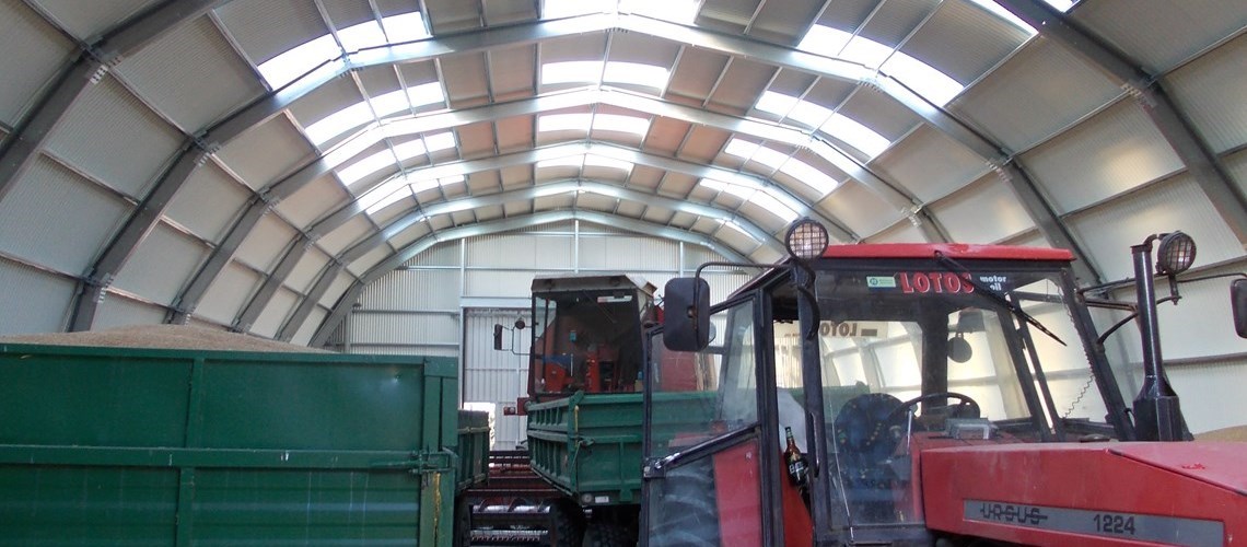 Vista interior de um celeiro usado para guardar maquinas agrícola como trator, colheitadeira, etc…